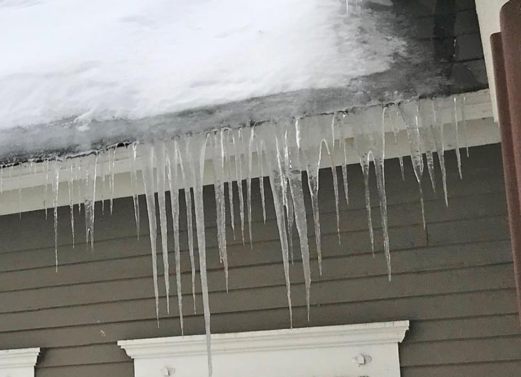 Snow+and+ice+backed+up+on+eaves+causing+icicles