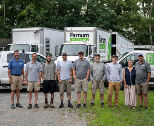Farnum Insulation team in Vermont standing in front of company trucks, highlighting their insulation expertise and professionalism