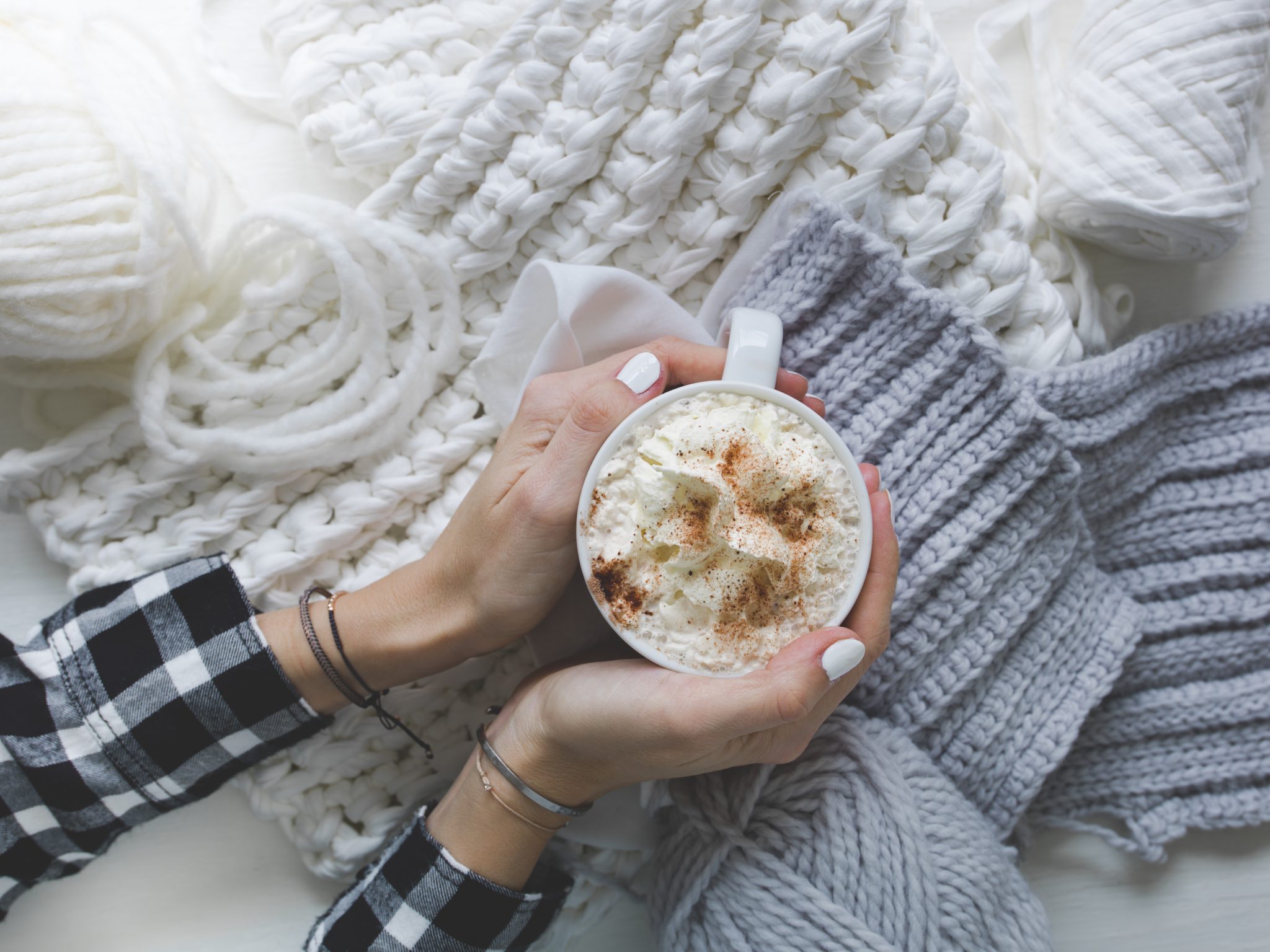 woman is holding a wonderful cup of hot chocolate with cream topping